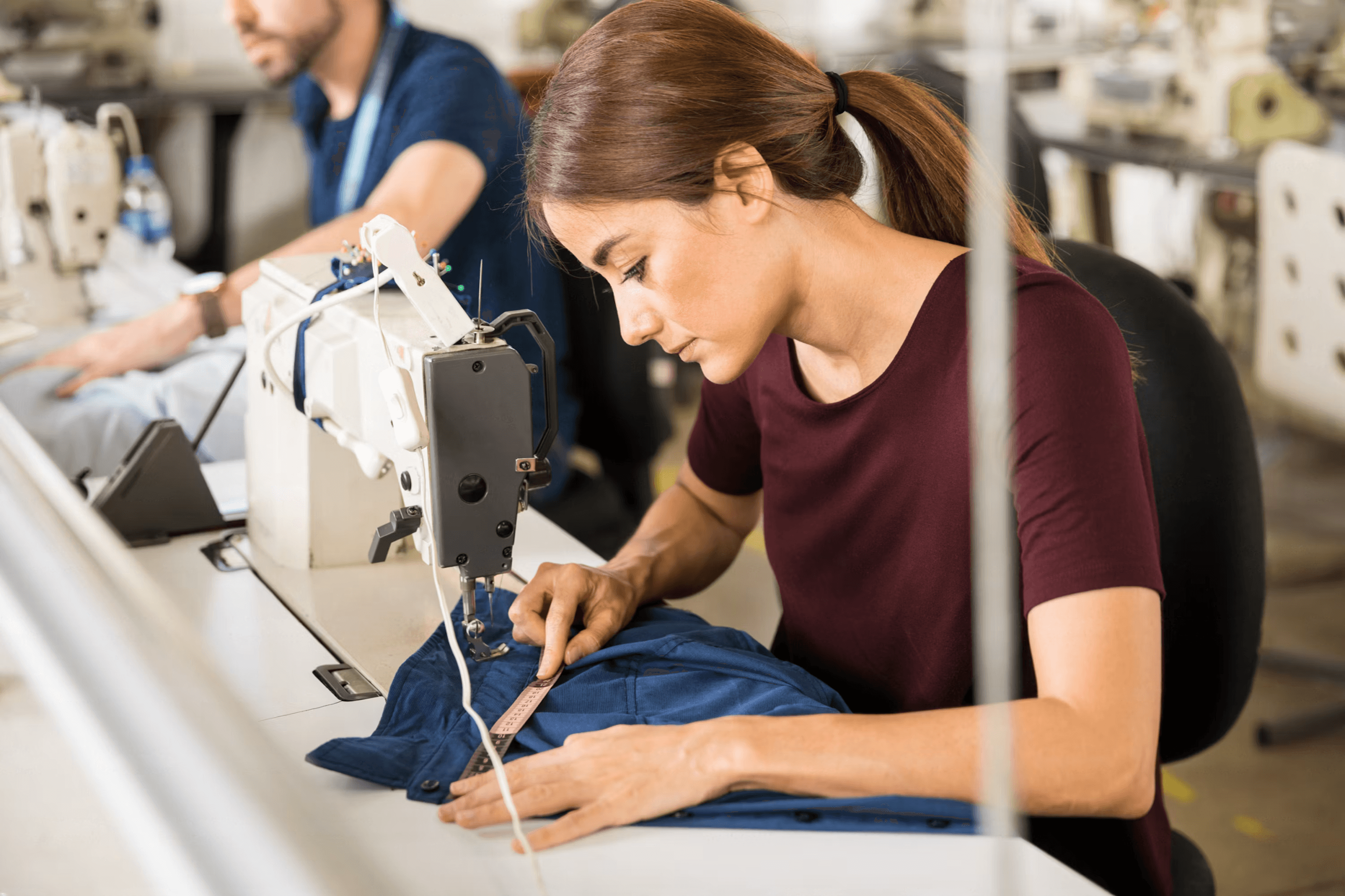 Garment factory worker at sewing machine
